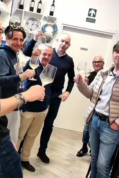 Brindisi con calici di vino bianco durante una degustazione in pescheria